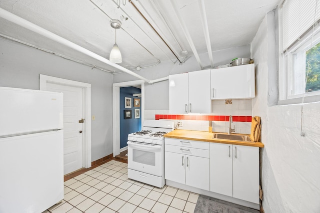 kitchen featuring white cabinetry, sink, backsplash, hanging light fixtures, and white appliances