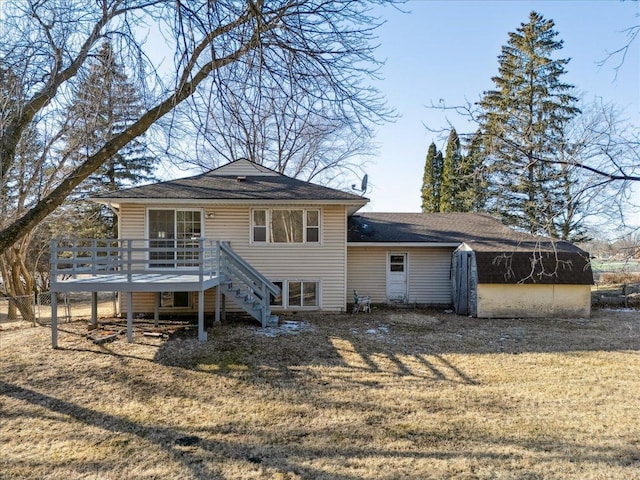 rear view of property featuring a wooden deck, a yard, and a shed