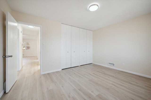 unfurnished bedroom featuring a closet and light hardwood / wood-style flooring