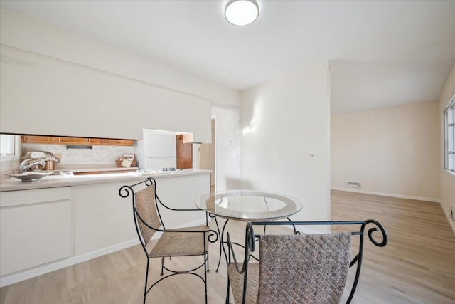 dining space featuring sink and light hardwood / wood-style flooring