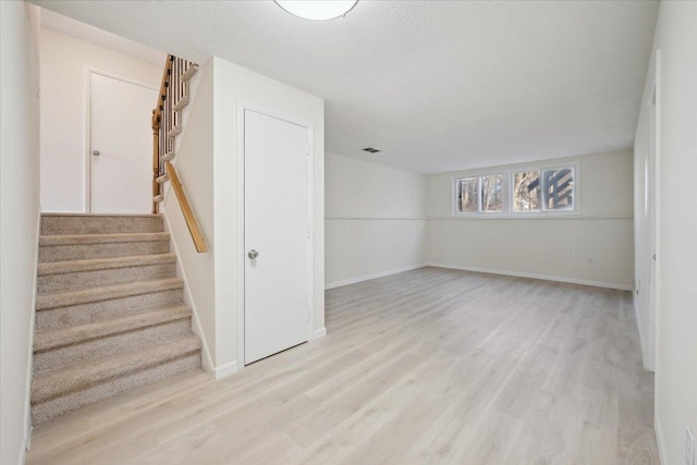 interior space with a textured ceiling and light wood-type flooring