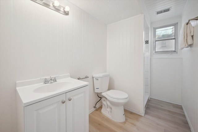 bathroom with vanity, a shower, wood-type flooring, and toilet