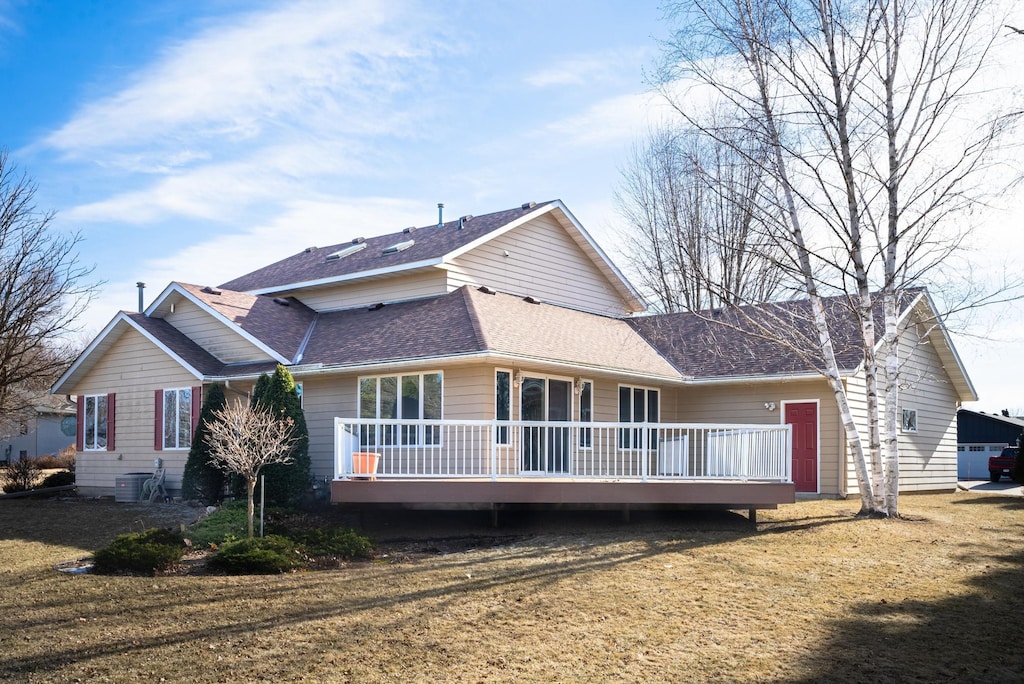 rear view of property with a yard and a deck