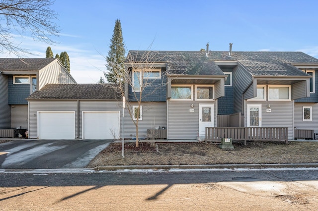 view of front of house with a garage, driveway, and roof with shingles