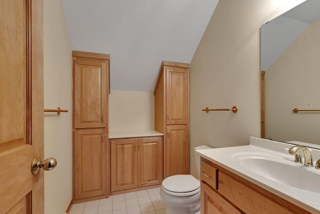 bathroom featuring lofted ceiling, vanity, tile patterned floors, and toilet