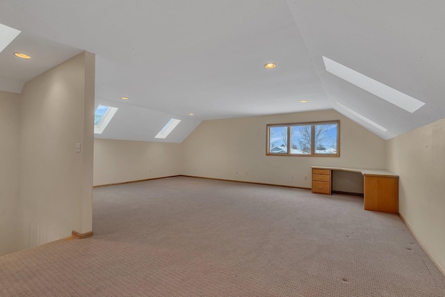 additional living space featuring light colored carpet and vaulted ceiling