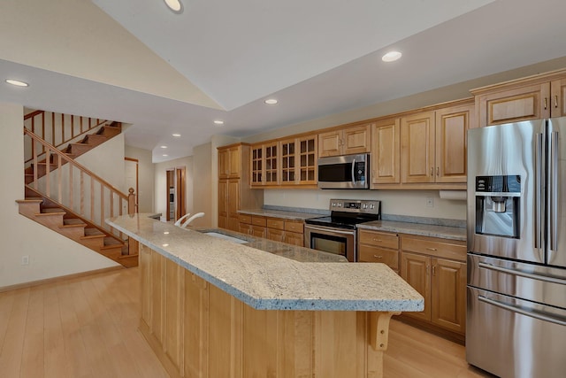 kitchen with sink, light stone countertops, an island with sink, and appliances with stainless steel finishes