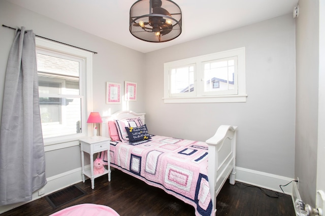 bedroom featuring multiple windows and dark hardwood / wood-style floors