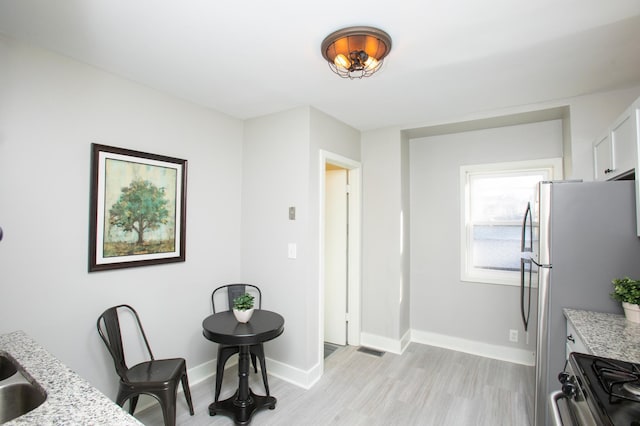 dining area featuring sink and light wood-type flooring