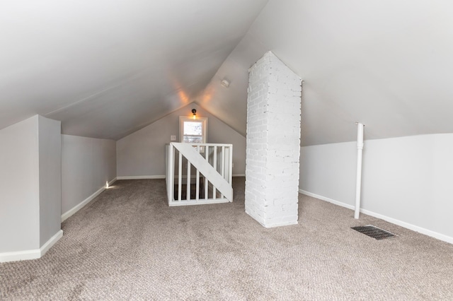 additional living space featuring vaulted ceiling and carpet