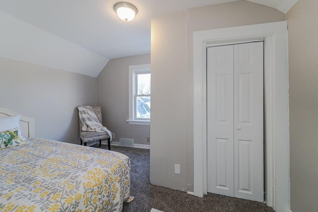 carpeted bedroom featuring lofted ceiling and a closet