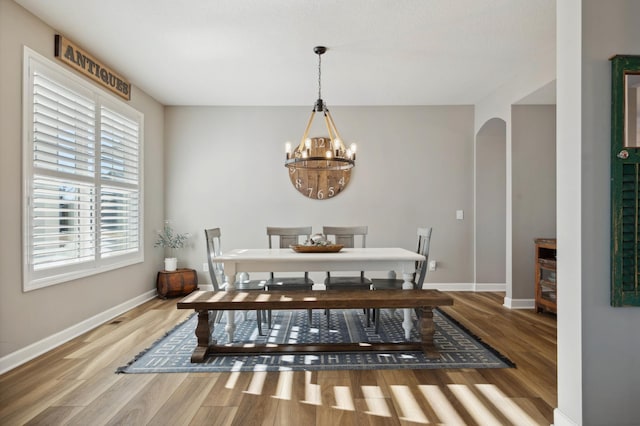 dining room with hardwood / wood-style flooring and an inviting chandelier