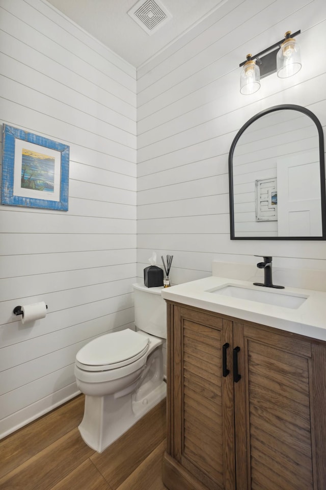 bathroom featuring vanity, wood-type flooring, and toilet