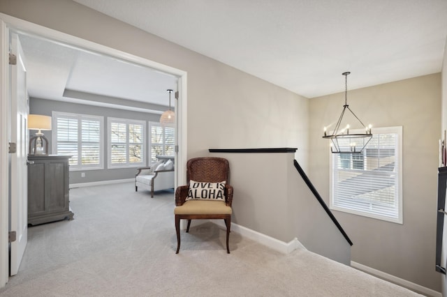 sitting room with an inviting chandelier and light colored carpet