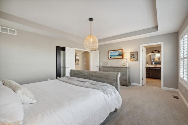 bedroom with light carpet and ensuite bathroom