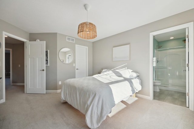 bedroom with light carpet and ensuite bath