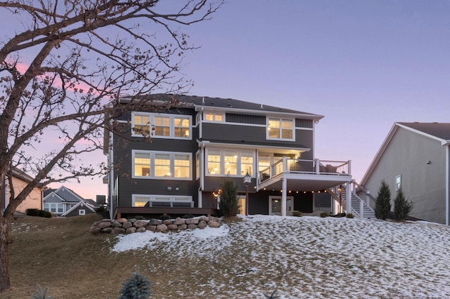 snow covered back of property featuring a deck