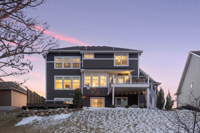 snow covered rear of property featuring a balcony