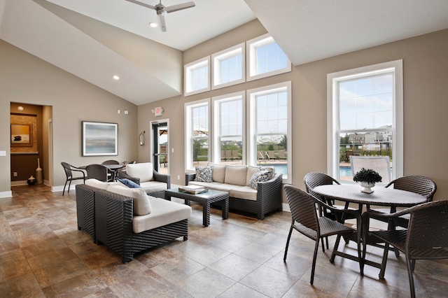 living room featuring ceiling fan and a high ceiling