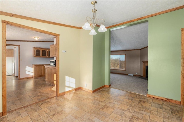 spare room with crown molding, an inviting chandelier, and a textured ceiling