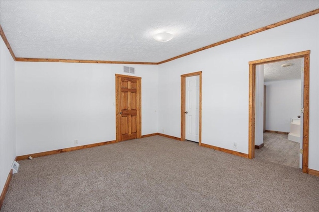 unfurnished room featuring ornamental molding, carpet floors, and a textured ceiling