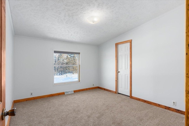 spare room with vaulted ceiling, light colored carpet, and a textured ceiling