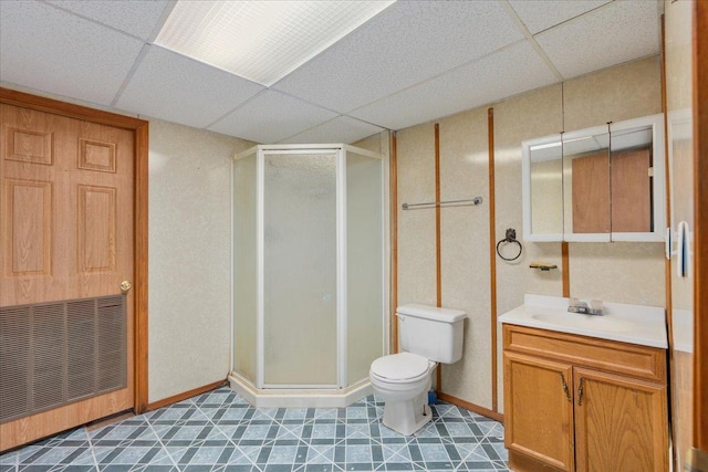 bathroom featuring walk in shower, a paneled ceiling, vanity, and toilet