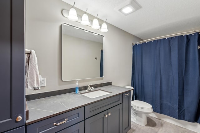 bathroom featuring vanity, a textured ceiling, and toilet