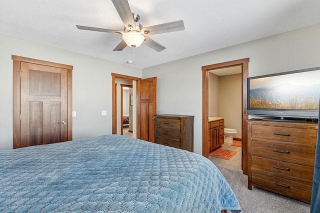 carpeted bedroom featuring ceiling fan and ensuite bath