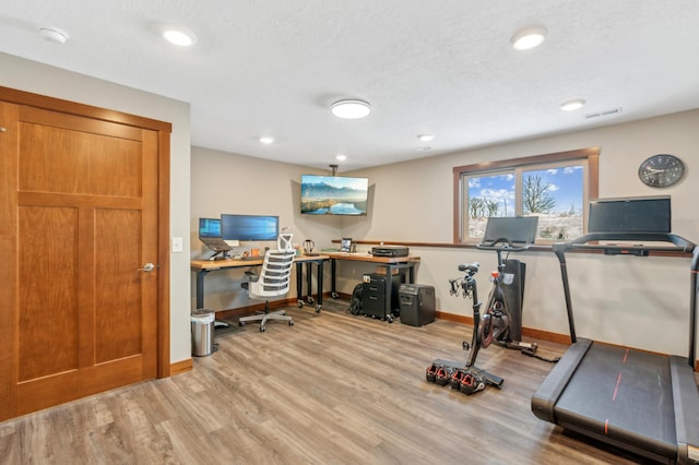 exercise room with hardwood / wood-style flooring and a textured ceiling