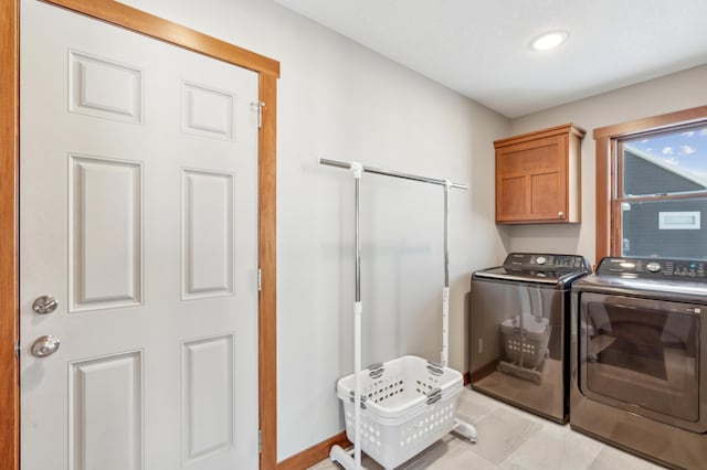 washroom with cabinets and washing machine and clothes dryer