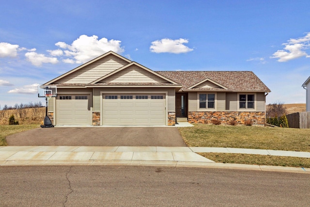 craftsman house featuring stone siding, an attached garage, aphalt driveway, and a front yard