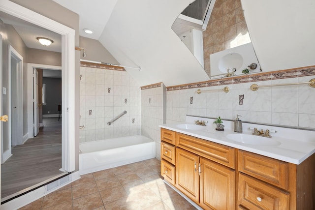 full bath featuring a tub, tile walls, a sink, and tile patterned floors