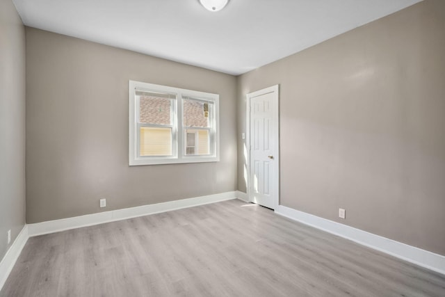 unfurnished room with baseboards and wood finished floors