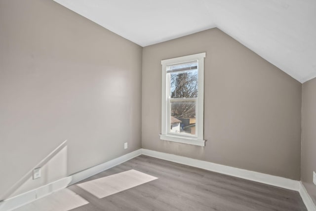 bonus room featuring lofted ceiling, baseboards, and wood finished floors