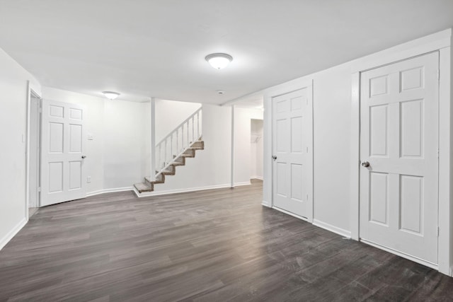 below grade area featuring baseboards, stairway, and dark wood-style flooring