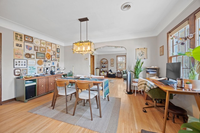 dining space featuring a notable chandelier and light wood-type flooring