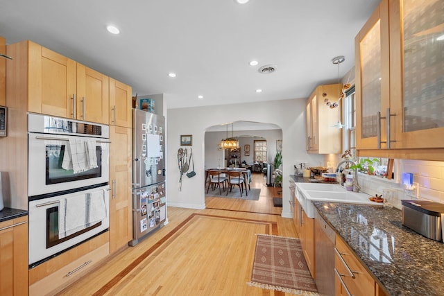 kitchen with pendant lighting, double oven, dishwashing machine, plenty of natural light, and light wood-type flooring