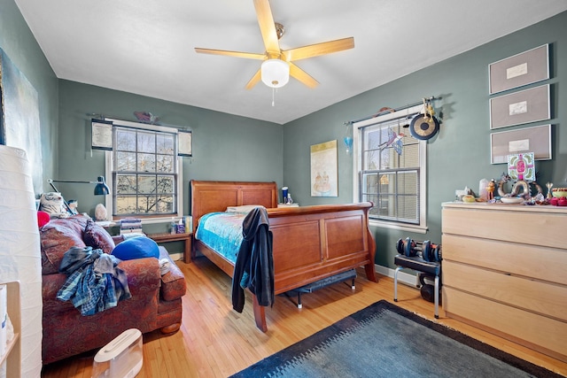 bedroom with multiple windows, light hardwood / wood-style floors, and ceiling fan