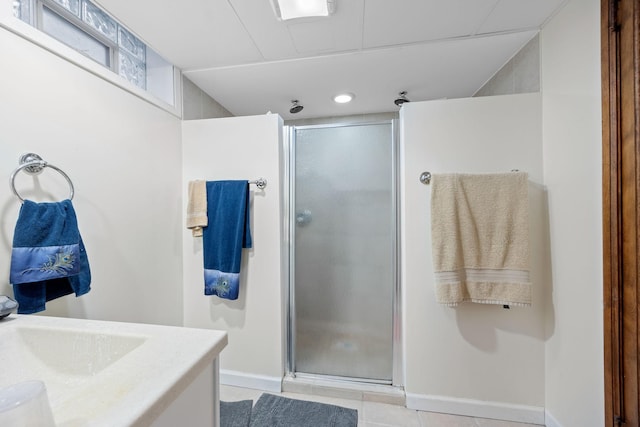 bathroom with walk in shower, vanity, and tile patterned flooring