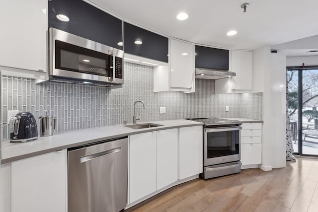 kitchen featuring stainless steel appliances, sink, white cabinets, and light hardwood / wood-style floors