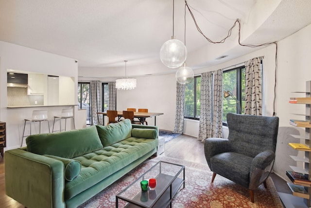 living room featuring a chandelier and light wood-type flooring