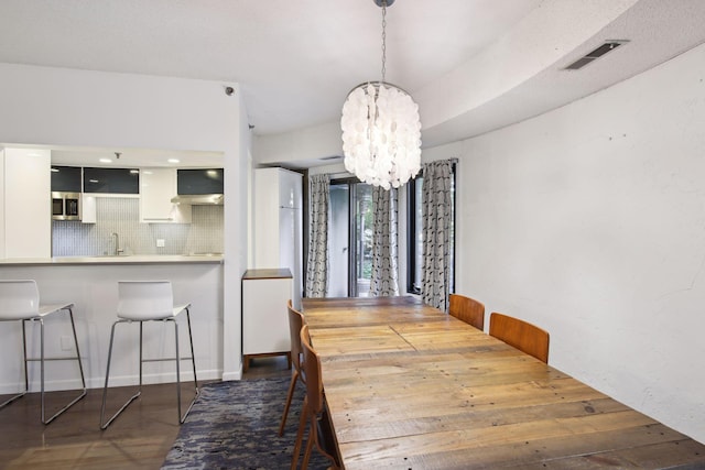 dining area featuring sink and a chandelier