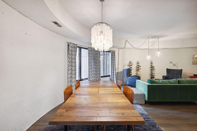 dining room featuring dark wood-type flooring and an inviting chandelier