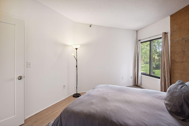 bedroom with hardwood / wood-style flooring and a textured ceiling