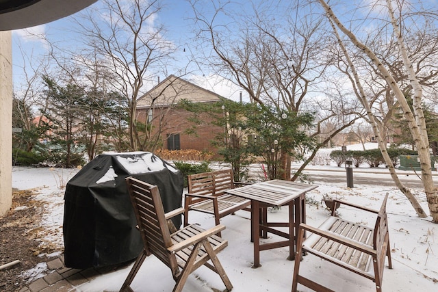 snow covered patio with a grill