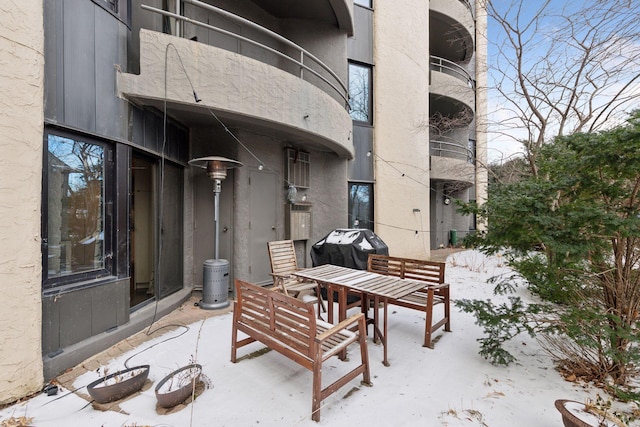 snow covered patio featuring a grill