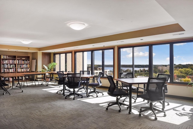 dining space with a water view and carpet