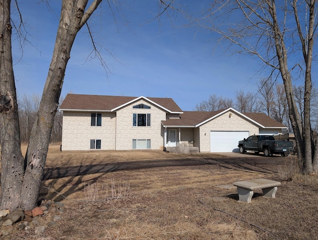 view of front of home featuring brick siding, a shingled roof, and a garage