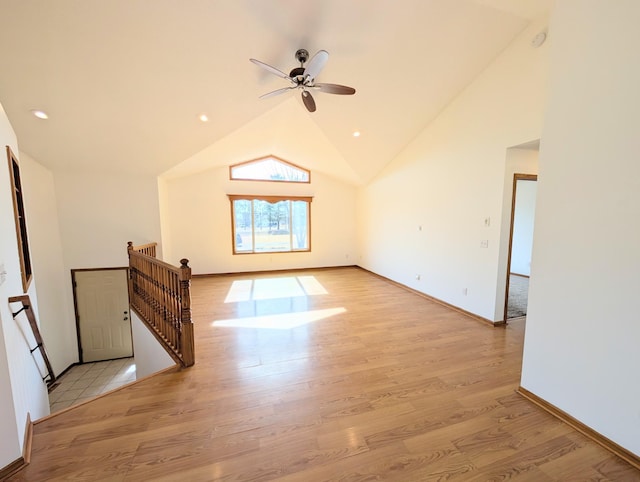 empty room featuring a ceiling fan, baseboards, high vaulted ceiling, light wood-style flooring, and recessed lighting